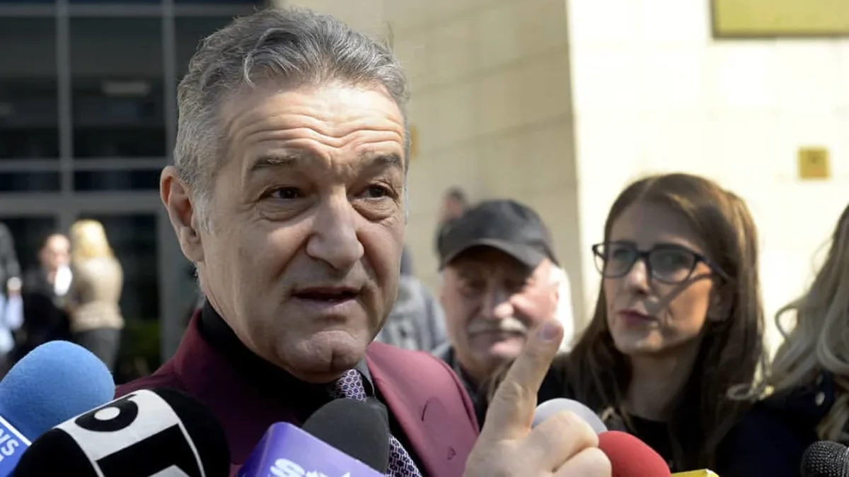 Gigi Becali vorbește în fața mai multor microfoane, cu degetul arătător ridicat, înconjurat de alte persoane.
